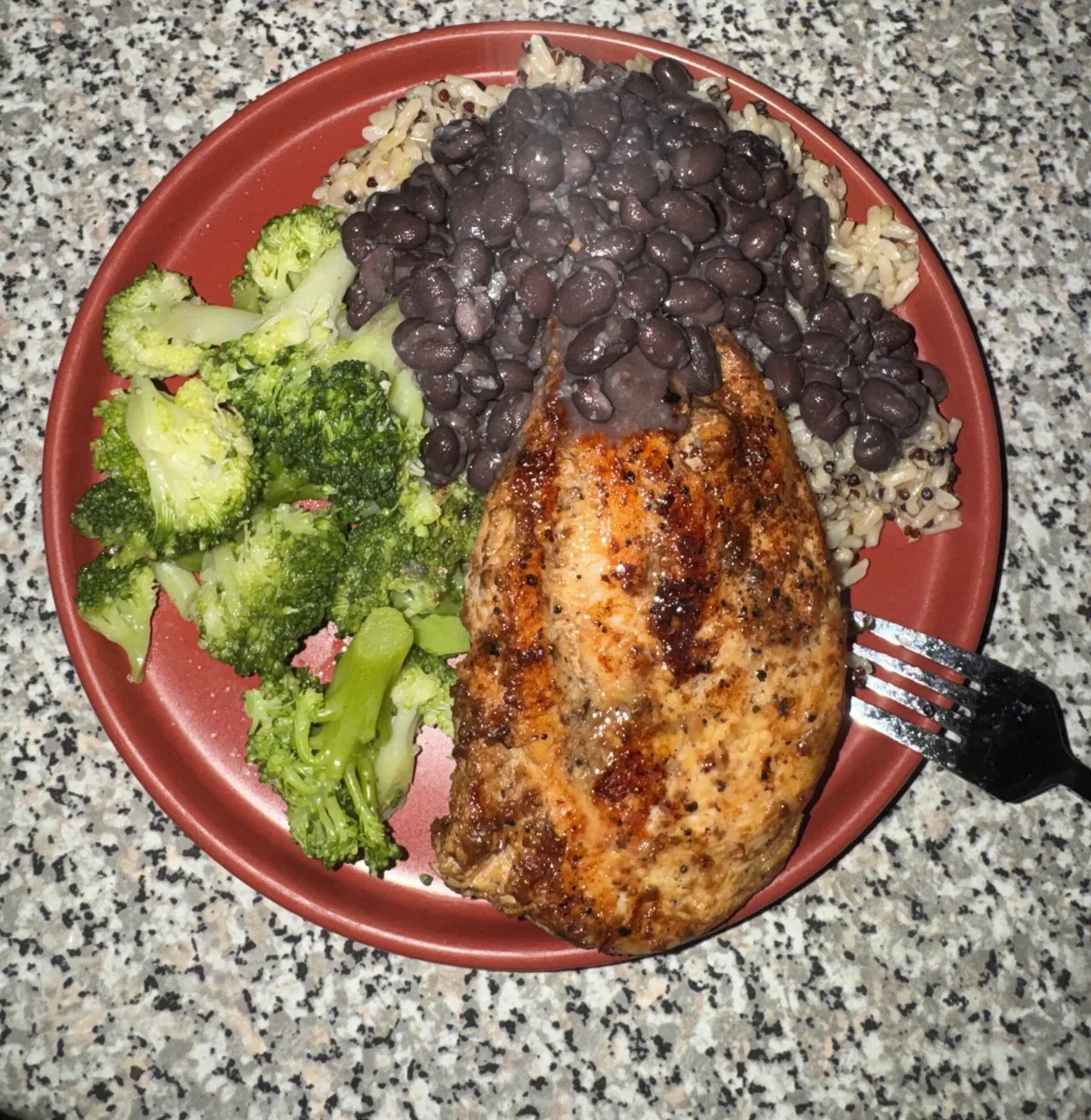 Homemade balanced plate with seasoned chicken breast, black beans over rice and broccoli
